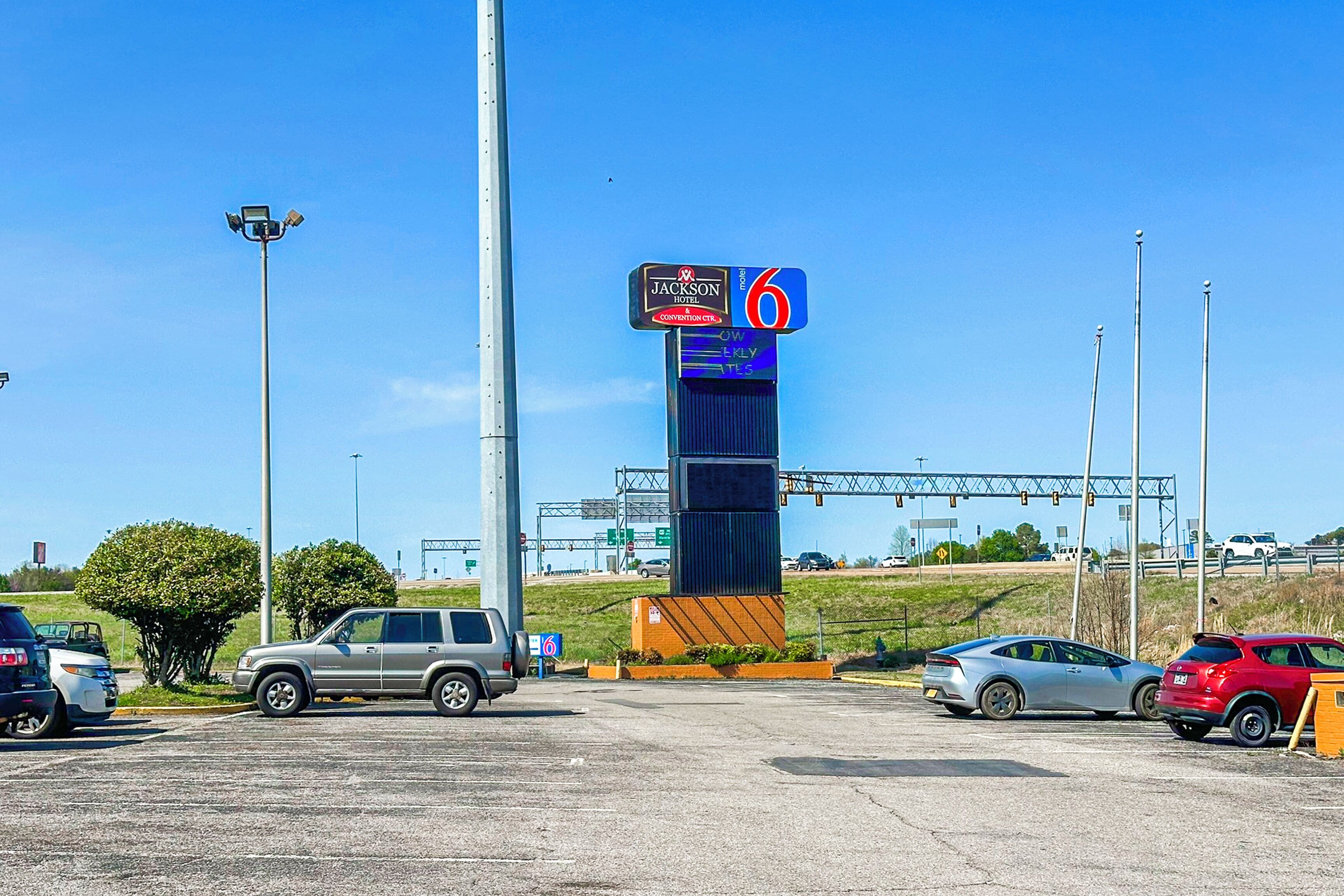 Um estacionamento com uma placa do Hotel Jackson e um '6' indicando o andar do estacionamento.