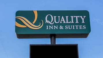 A sign for Quality Inn & Suites with a stylized logo and text.