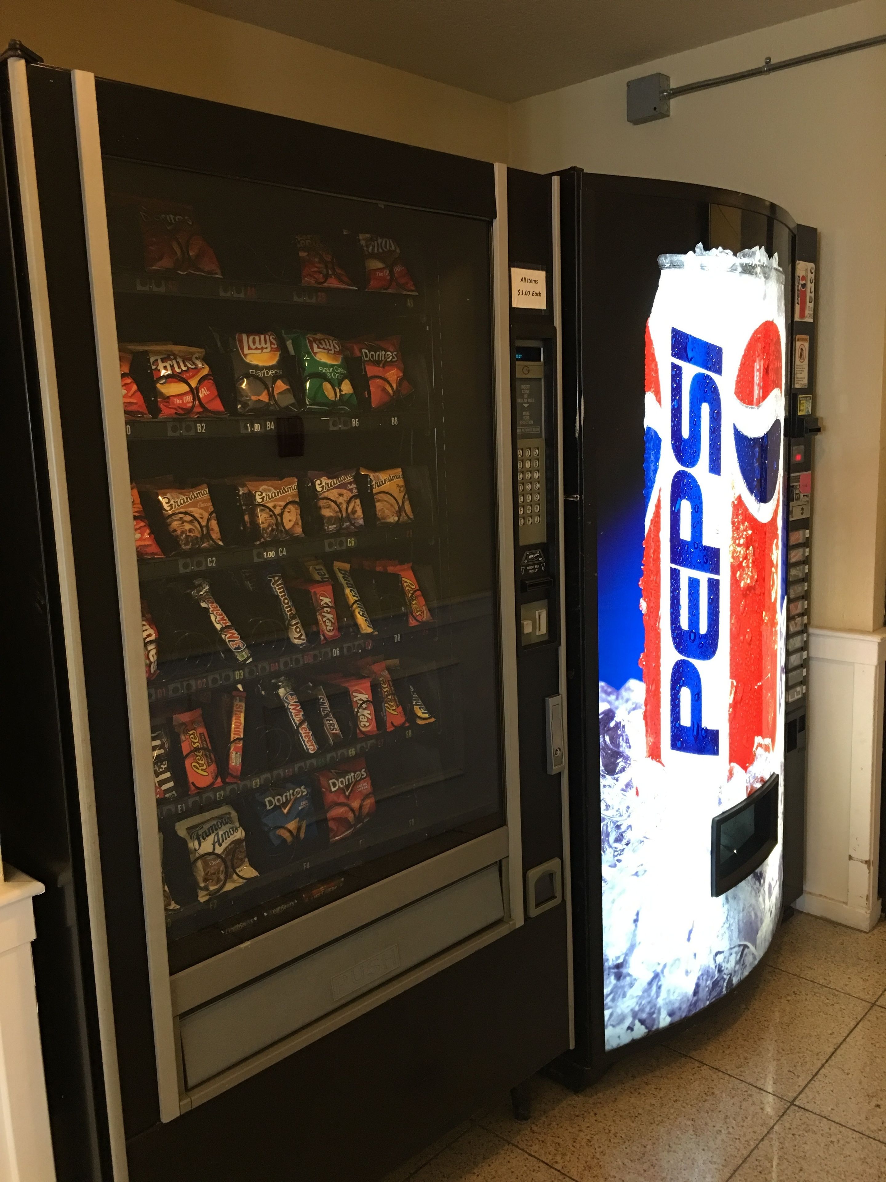A vending machine stocked with various snacks and a Pepsi advertisement.