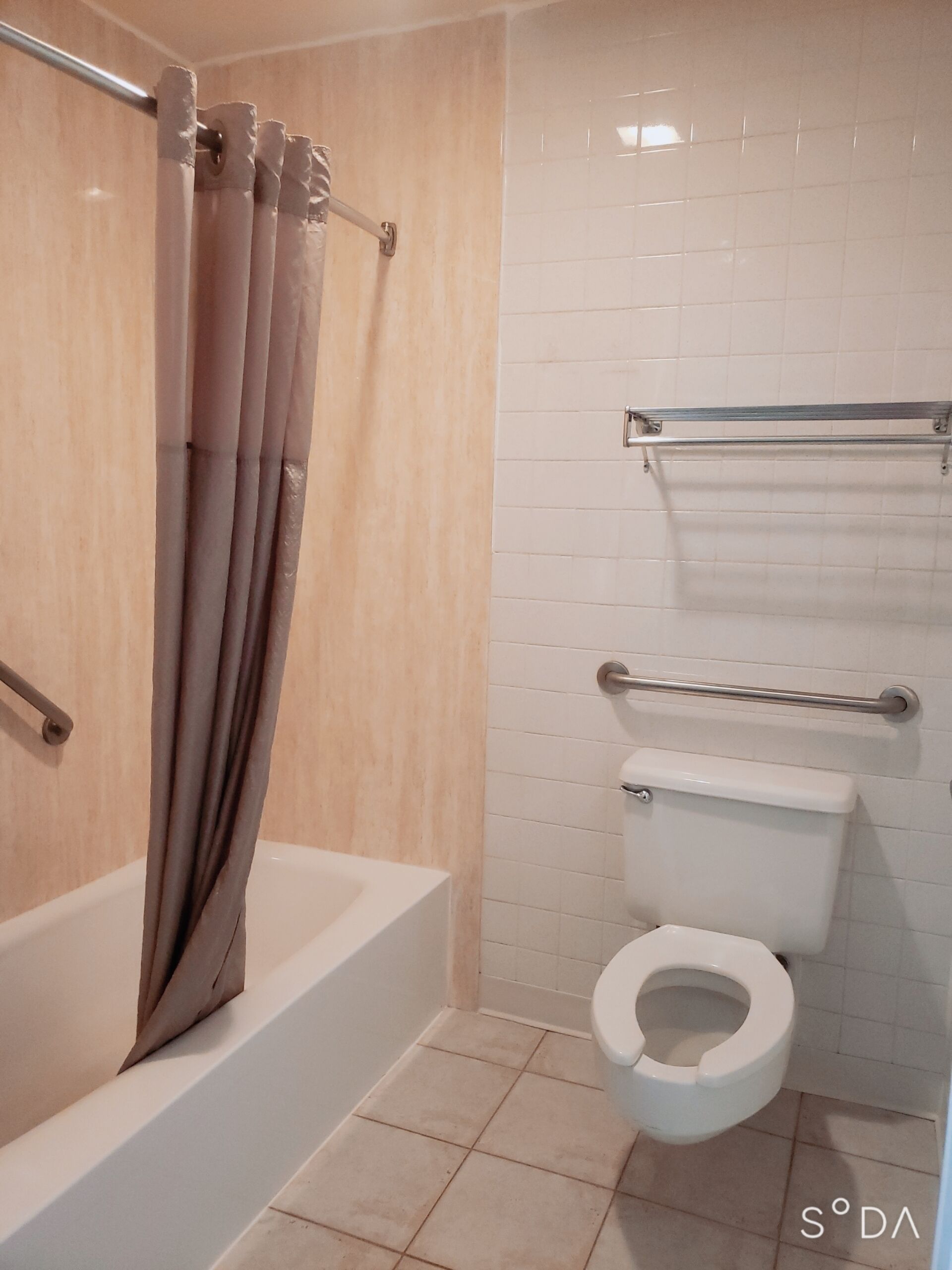 Een badkamer met bad, toilet en douchegordijn.