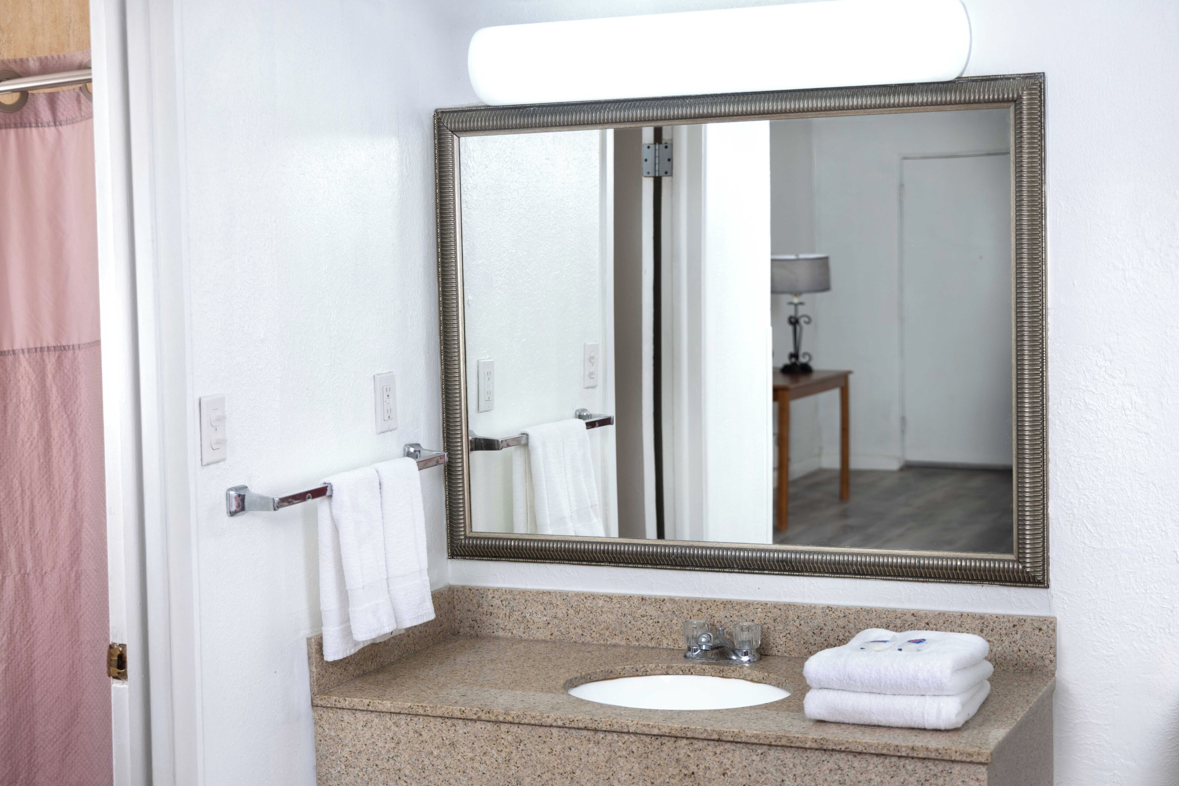 Une salle de bain équipée d’un lavabo, d’un miroir et d’un porte-serviettes.