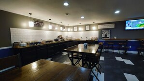 A modern kitchen with white subway tiles, a wooden table, and a bar area with stools. - Greenfield Inn and Suites Elizabethtown, KY I65 Exit 94 (Elizabethtown)