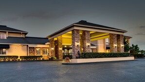 A hotel with a covered entrance, stone pillars, and a well-lit facade. - Greenfield Inn and Suites Elizabethtown, KY I65 Exit 94 (Elizabethtown)