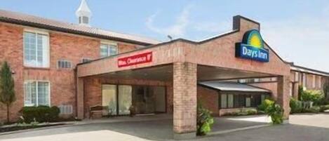 A Days Inn hotel with a brick facade, a covered entrance, and a visible sign for the restaurant.