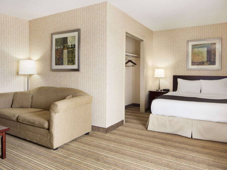 Ein Hotelzimmer mit Bett, Schlafsofa, Schreibtisch und Kleiderschrank.