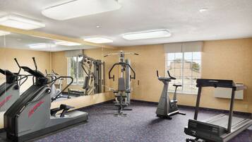 A gym with treadmills, elliptical machines, and weight equipment.