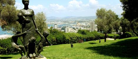 Una estatua en un parque, con un paisaje urbano de fondo.