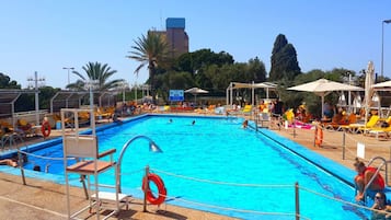 Una piscina al aire libre de temporada, sombrillas