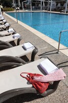 Una piscina al aire libre de temporada, sombrillas