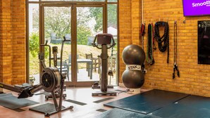 A gym with exercise equipment, a large window, and a sign on the wall.