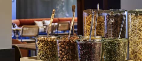 A variety of food items in glass containers with spoons, arranged on a wooden surface.