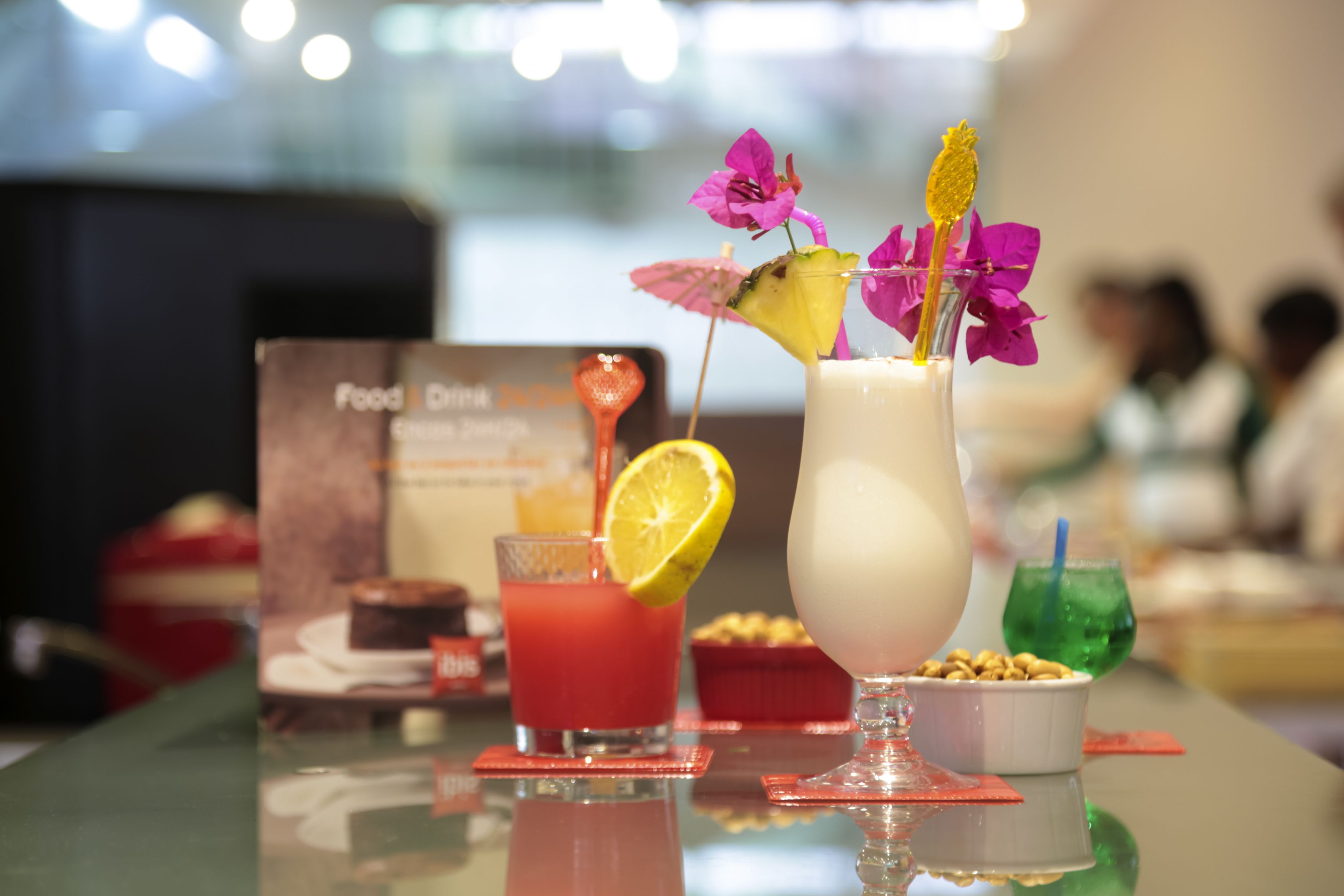 A bar area with a food and drink menu, a variety of drinks, and a small bowl of nuts.