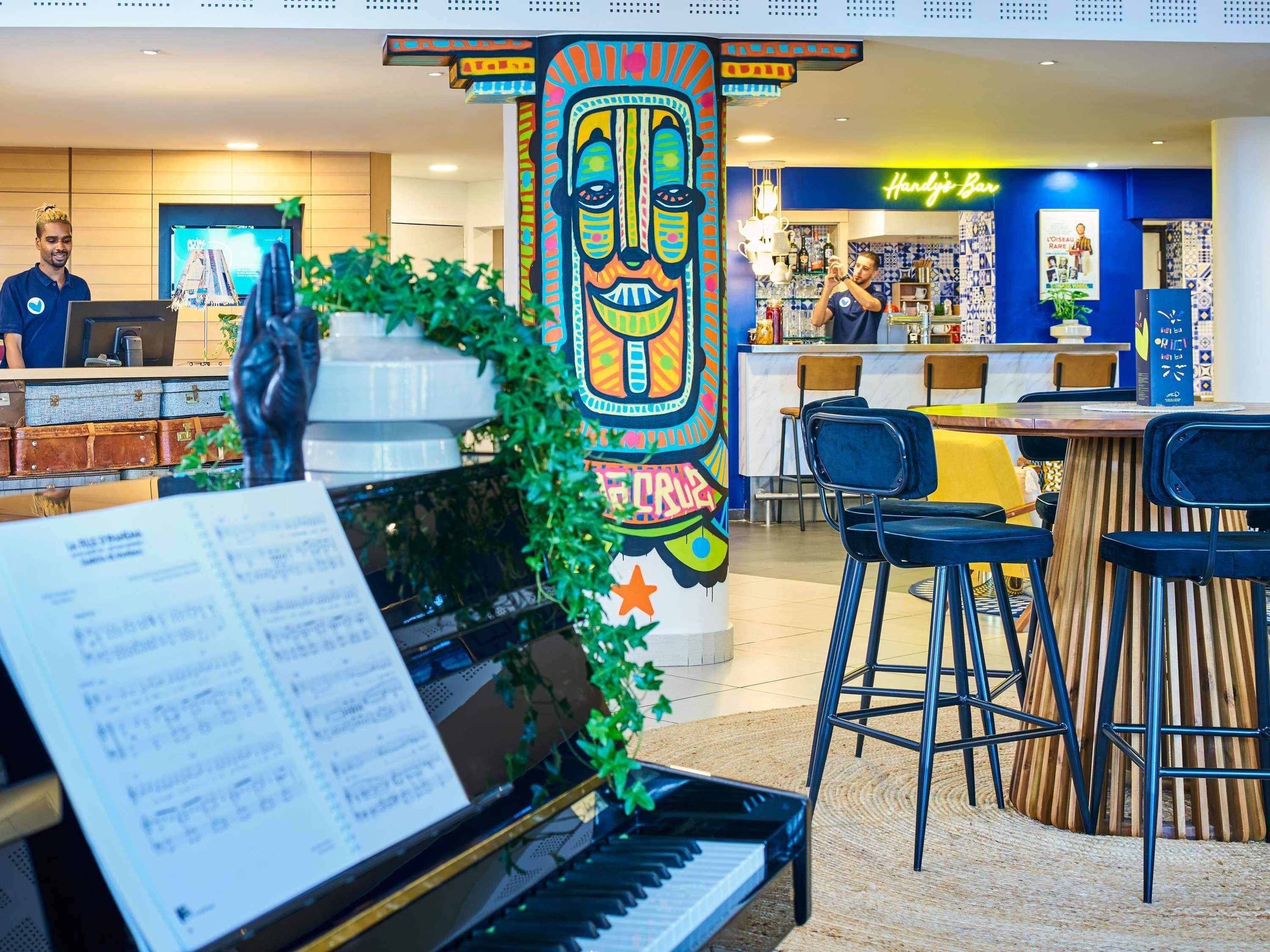 Un espace d’accueil comprenant un piano, un bar et un comptoir.