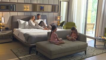 Relax in a spacious room with a large bed, sofa, and table, offering a view of the outdoors.