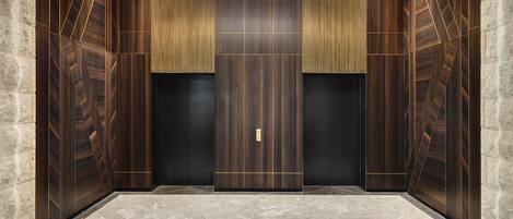 A modern elevator with wooden paneling and a geometric design.