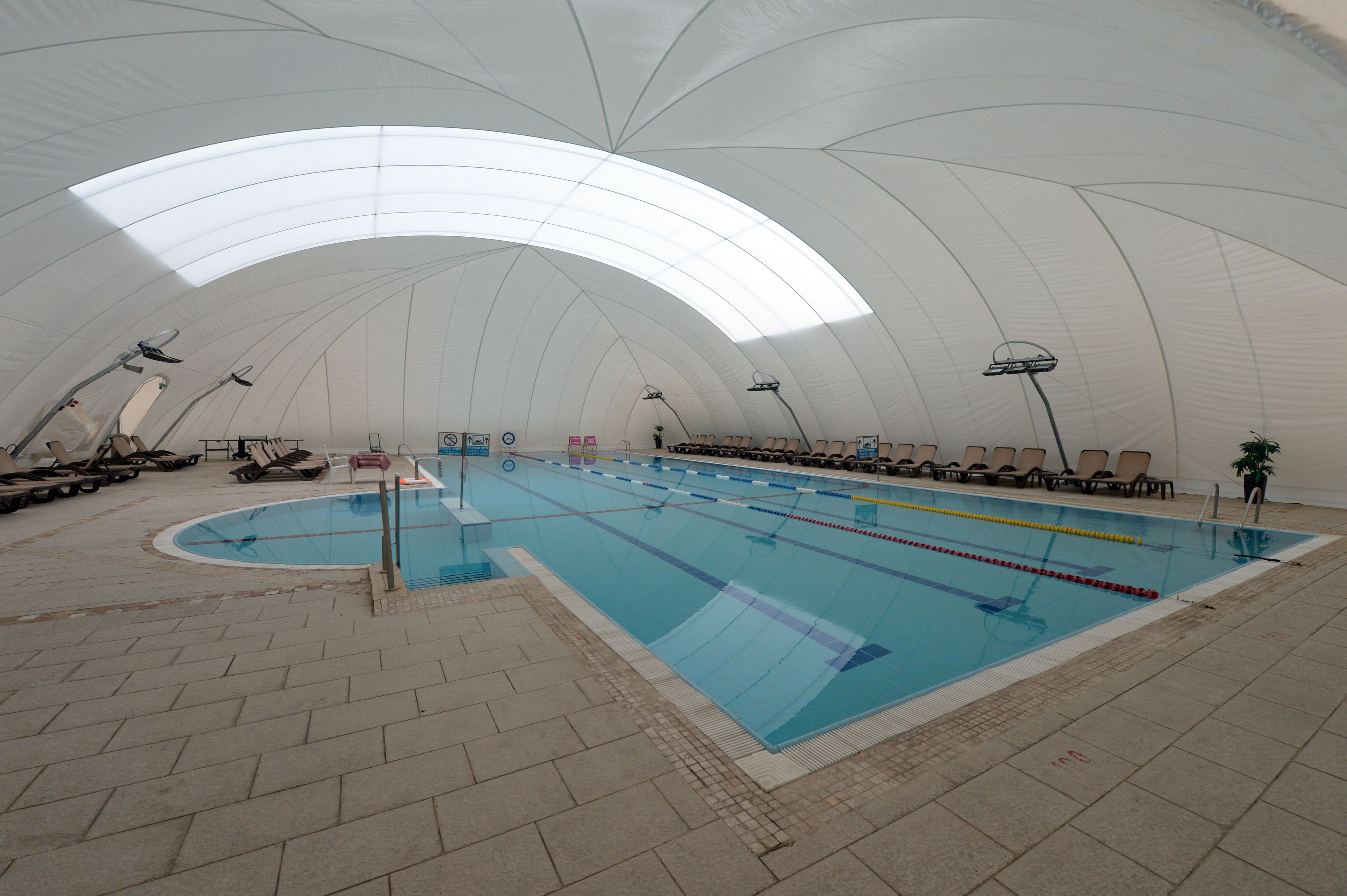 Una piscina interior con techos altos y abovedados, y varias pistas de natación.