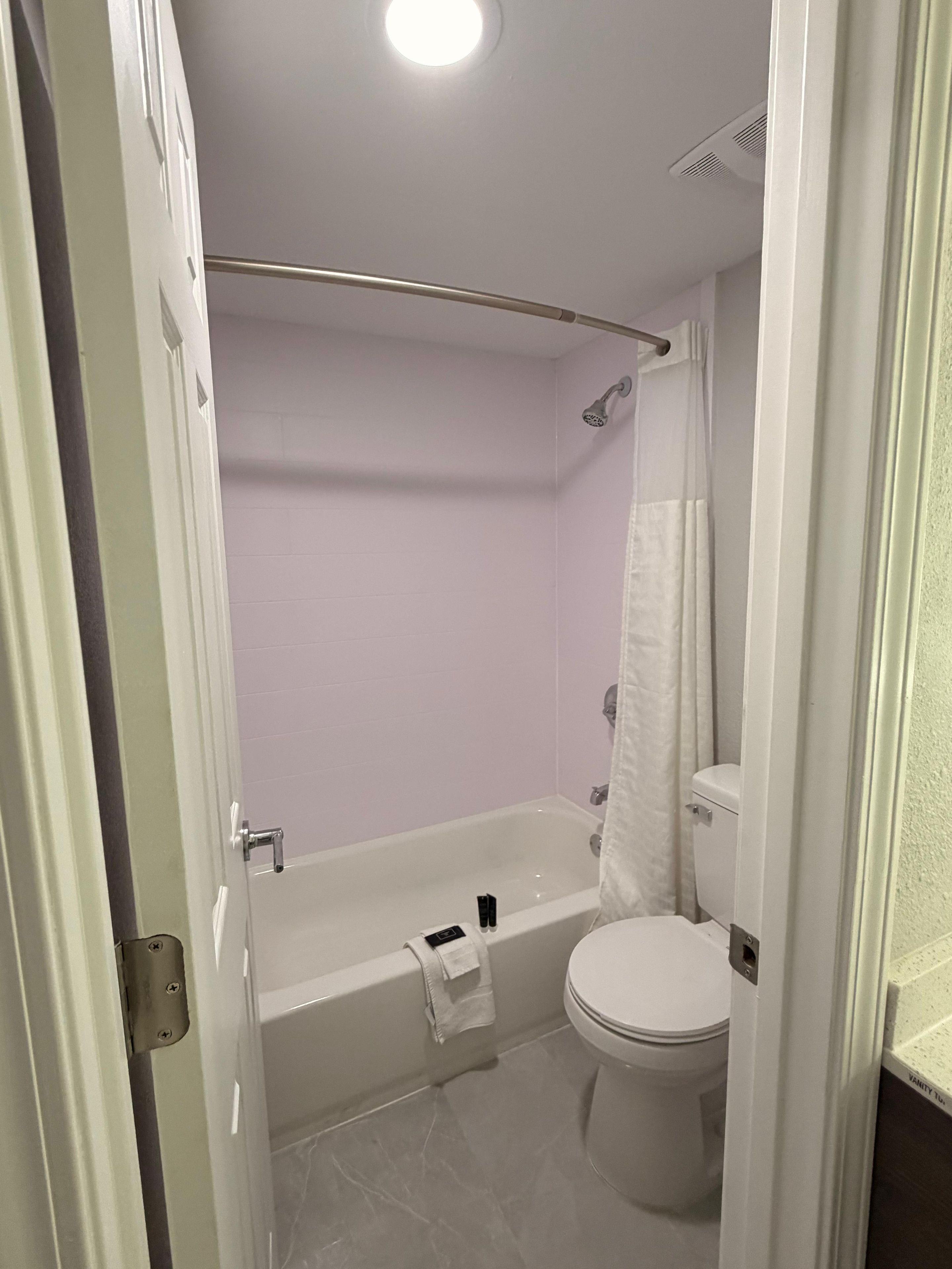 Kylpyhuone, jossa on kylpyamme, wc ja suihkuverho.
