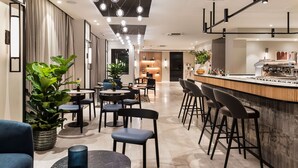 A modern hotel lobby with a bar area, seating arrangements, and a dining area. - Ambasciatori Hotel Mestre Venice, Tapestry Collection by Hilton (Mestre)