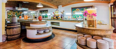 A restaurant with a rustic interior, featuring a brick ceiling, wooden barrels, and a counter with stacked plates.