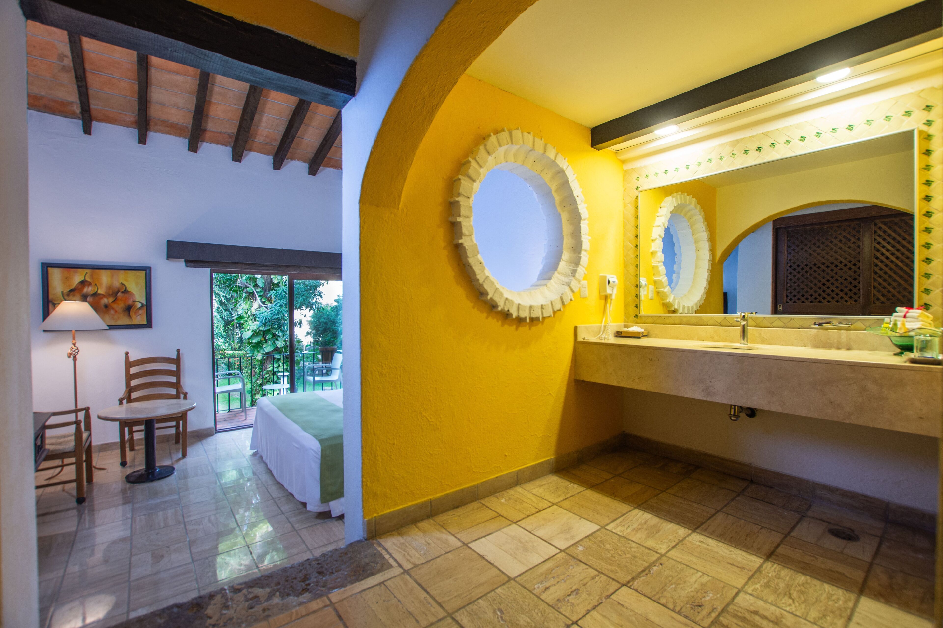 A bathroom with a large mirror, a sink, and a window.