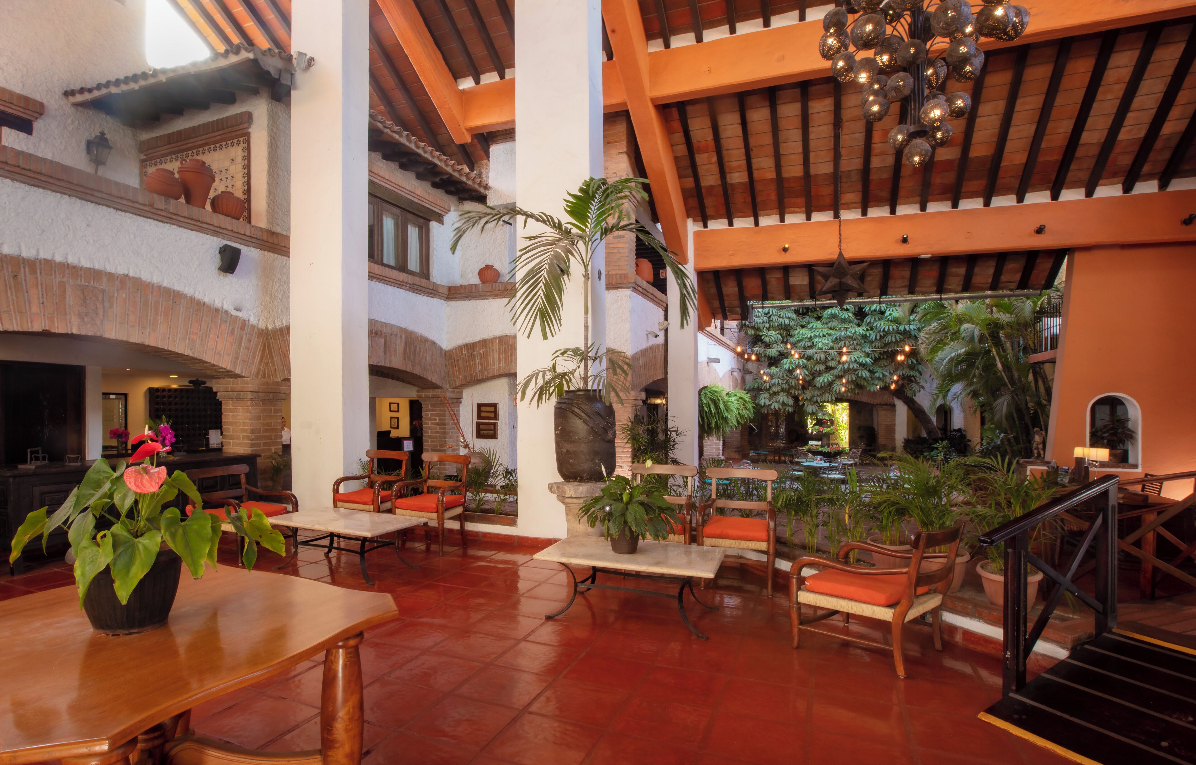En rymlig entréhall med högt i tak, synliga träbjälkar och en central fontän.
