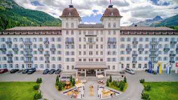 Un gran hotel con dos imponentes torres abovedadas, una entrada central y un área exterior bien cuidada.
