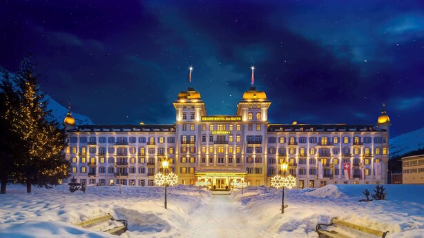 A grand hotel with a symmetrical facade, two prominent towers, and a snow-covered entrance.