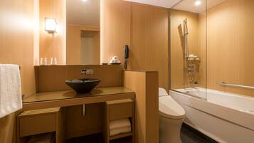 A modern bathroom with a wooden vanity, a sink with a bowl, a toilet, and a bathtub.