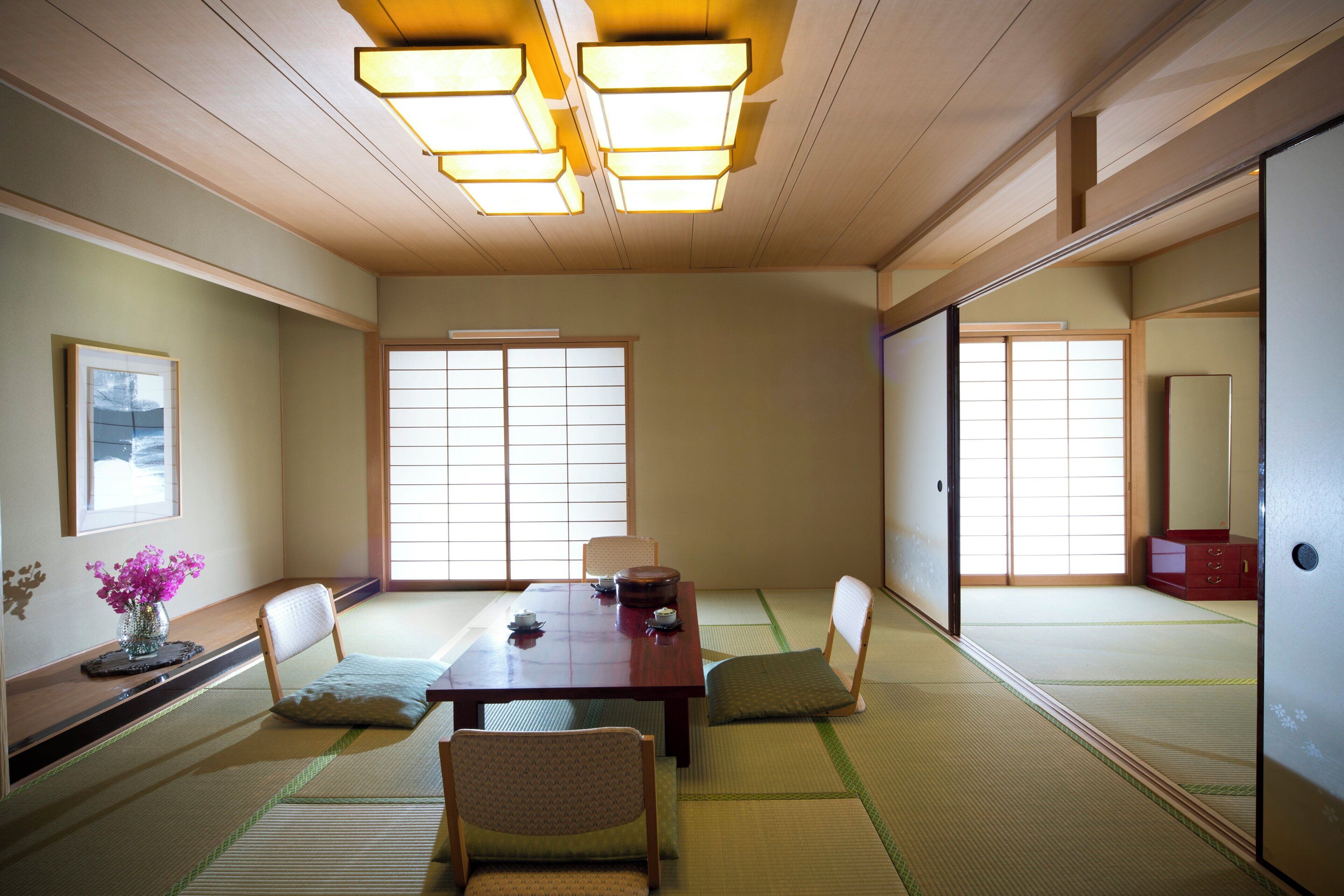 Um quarto japonês tradicional, com piso de tatame, uma mesa baixa e biombos shoji.