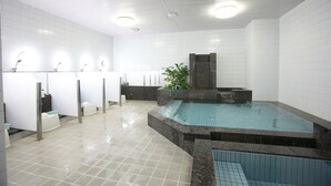 Een moderne badkamer met een centraal gelegen whirlpool, meerdere wastafels en een betegelde vloer.