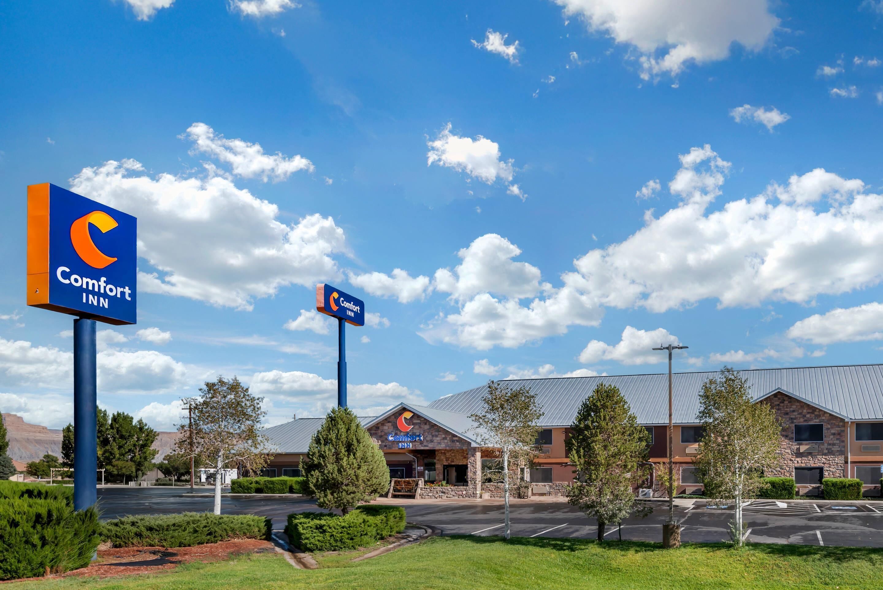 A Comfort Inn hotel with a clear blue sky and clouds.