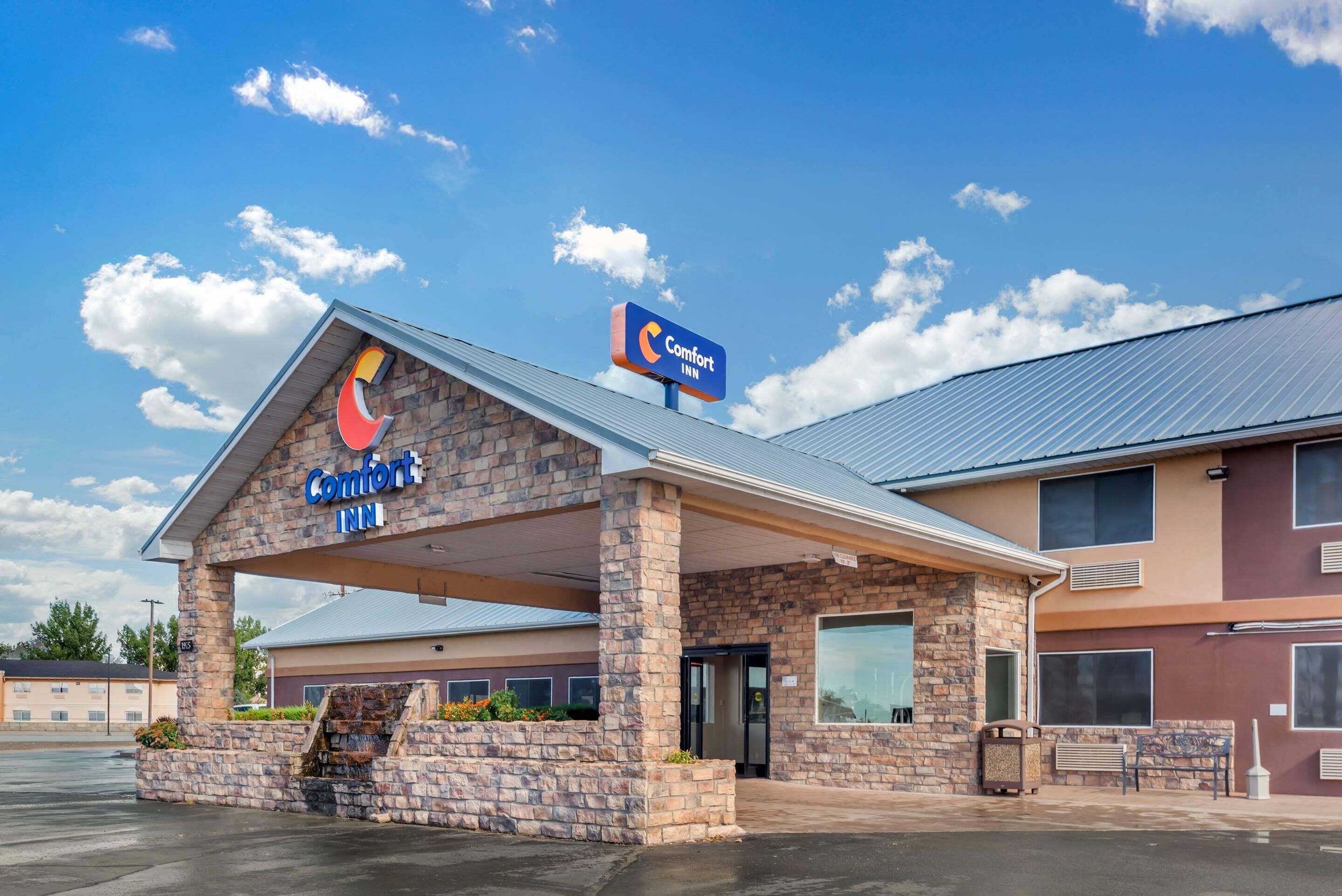 Un Comfort Inn con fachada de piedra y entrada cubierta.