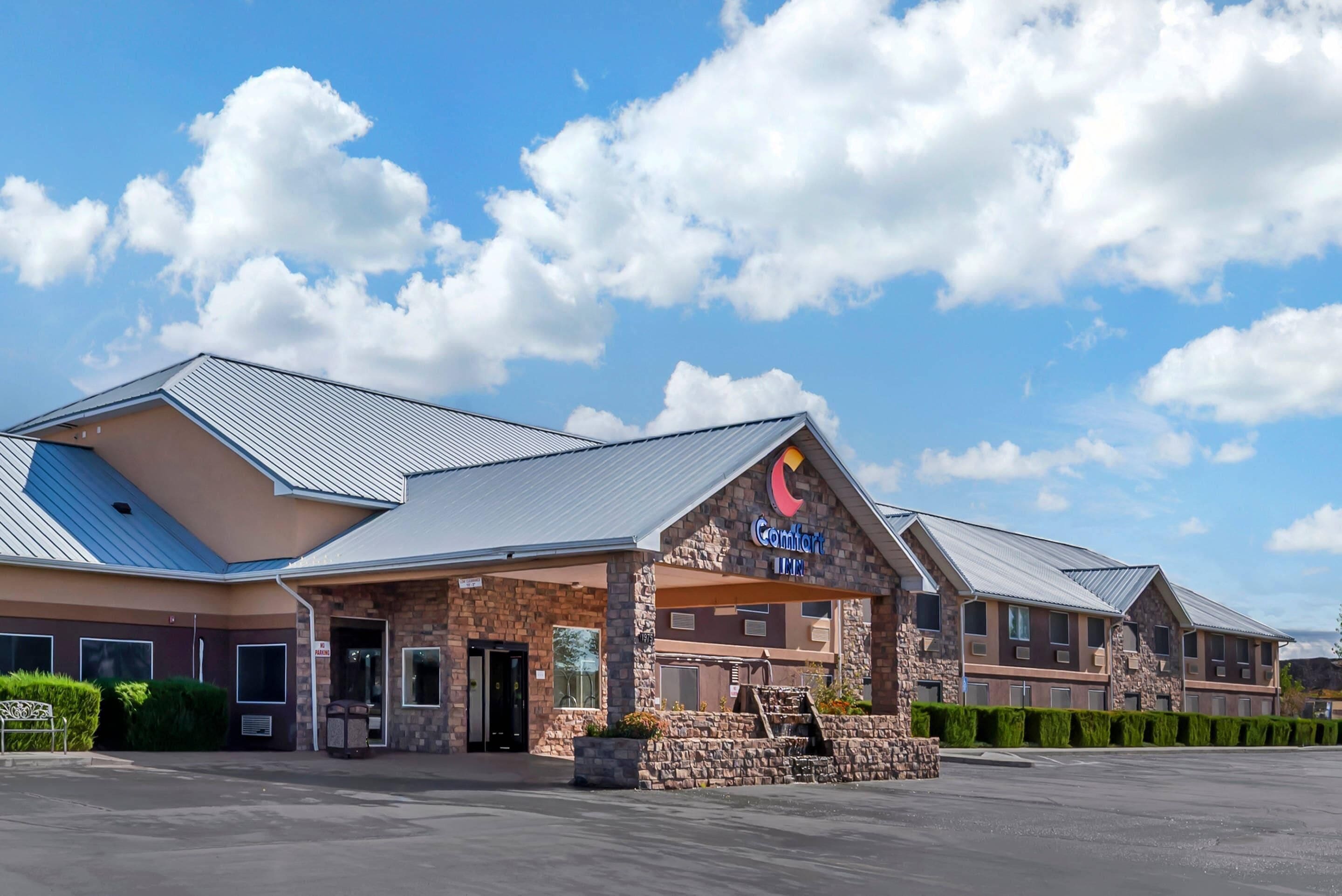 A hotel with a stone facade, a metal roof, and a sign reading "Comfort Inn."