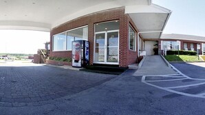 A gas station with a brick facade, large windows, and a covered entrance. - Motel 6 – Chillicothe, MO (Chillicothe)