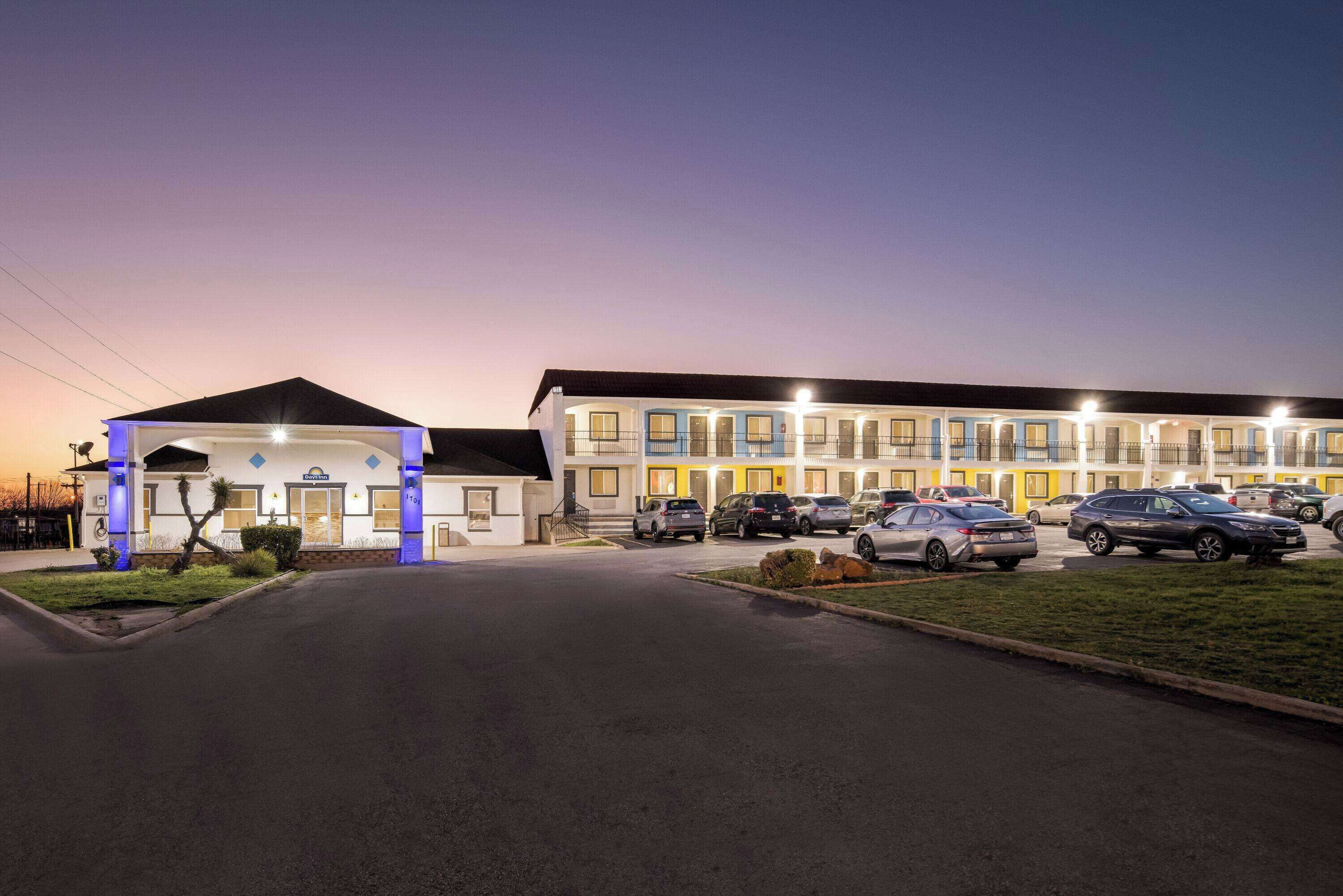 Ein Motel mit überdachter Zufahrt und mehreren Parkplätzen.