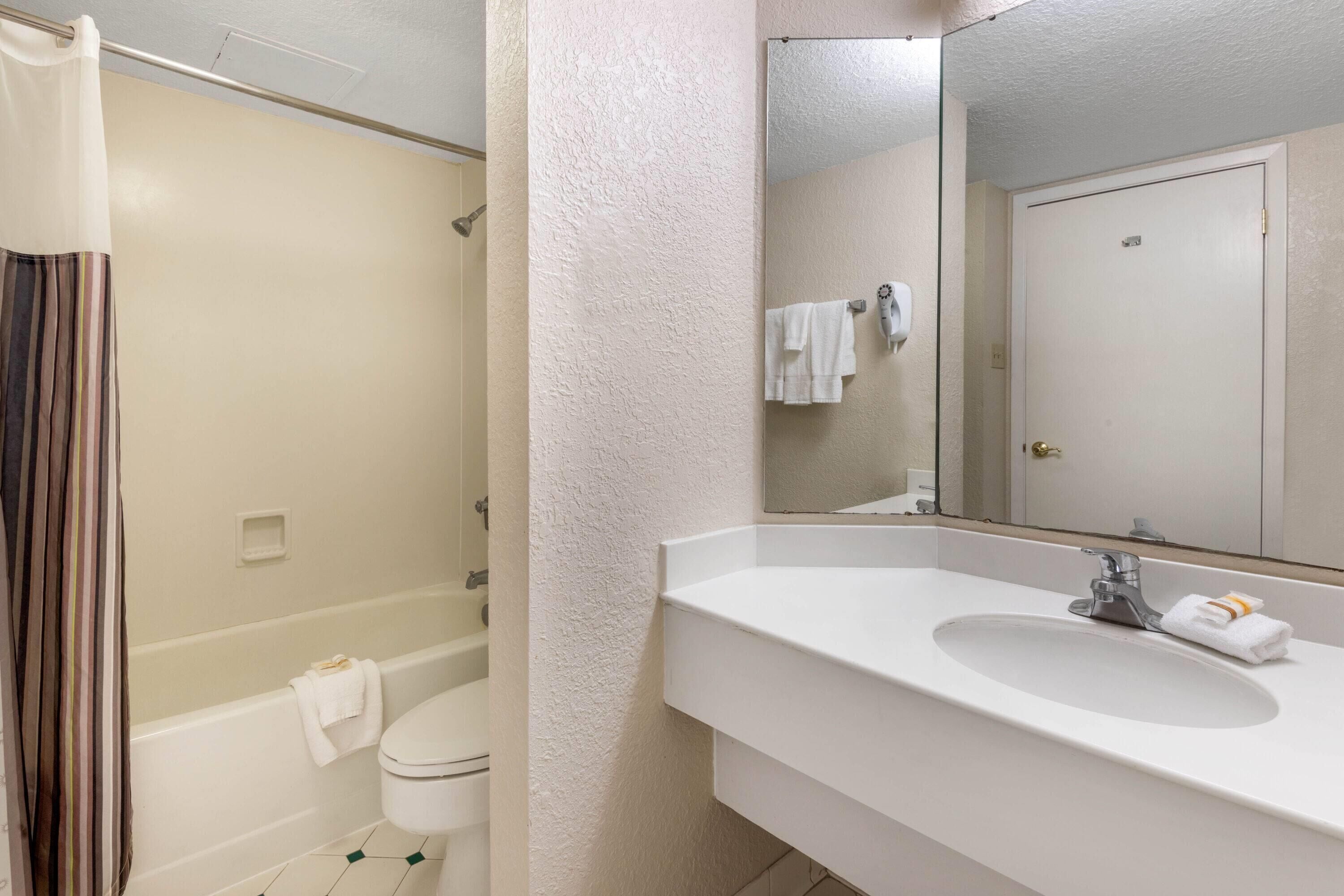 Une salle de bain avec une baignoire, des toilettes, un lavabo et un miroir.