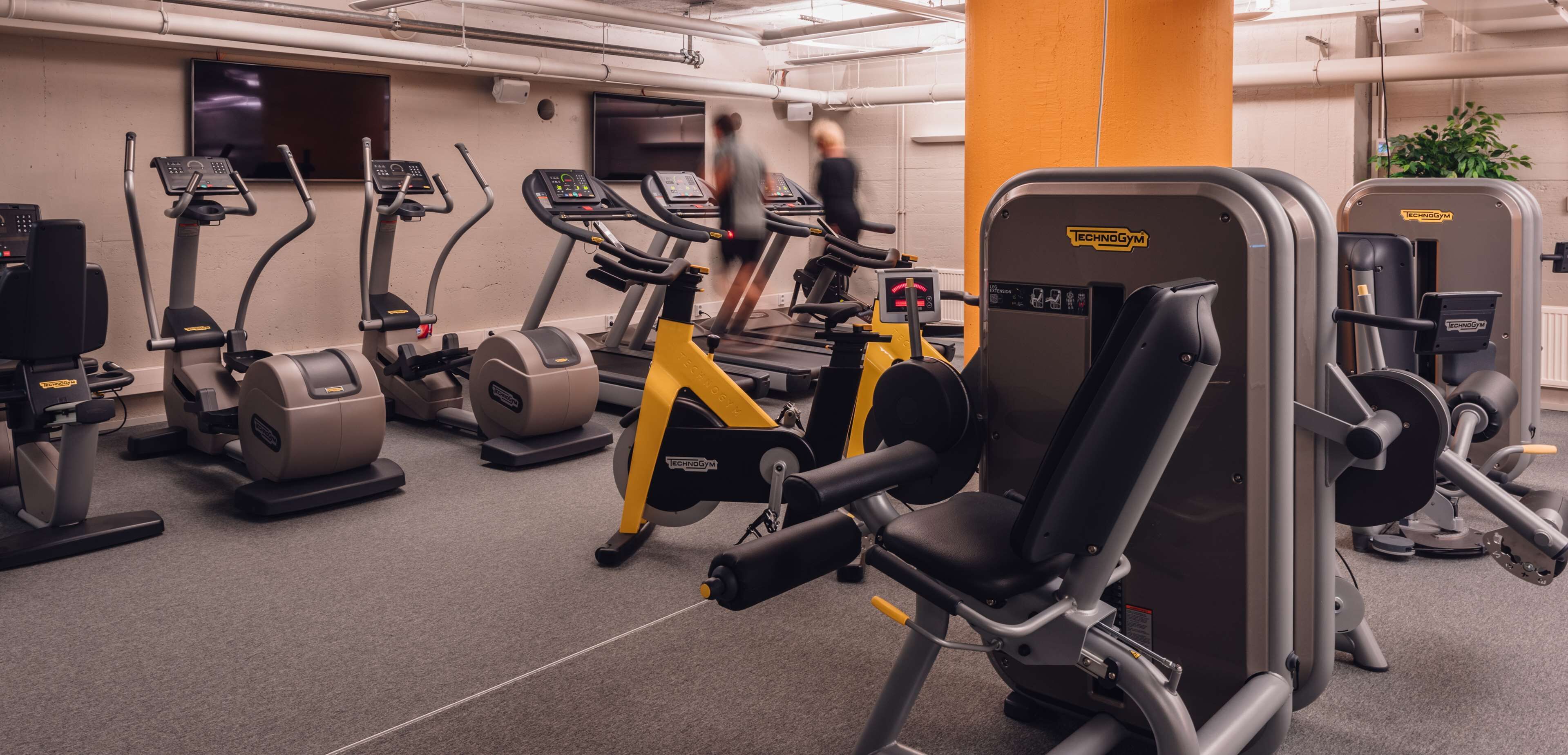 A gym with various exercise machines, including treadmills and weight stations.