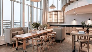 A modern hotel room with a large window, a wooden dining table, and a kitchen area. - Radisson Blu Seaside Hotel, Helsinki (Helsinki)