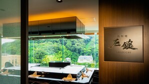 Ein Restaurant mit Blick auf eine bewaldete Landschaft, einer Holzwand mit einer Plakette und einem modernen Innenraum.