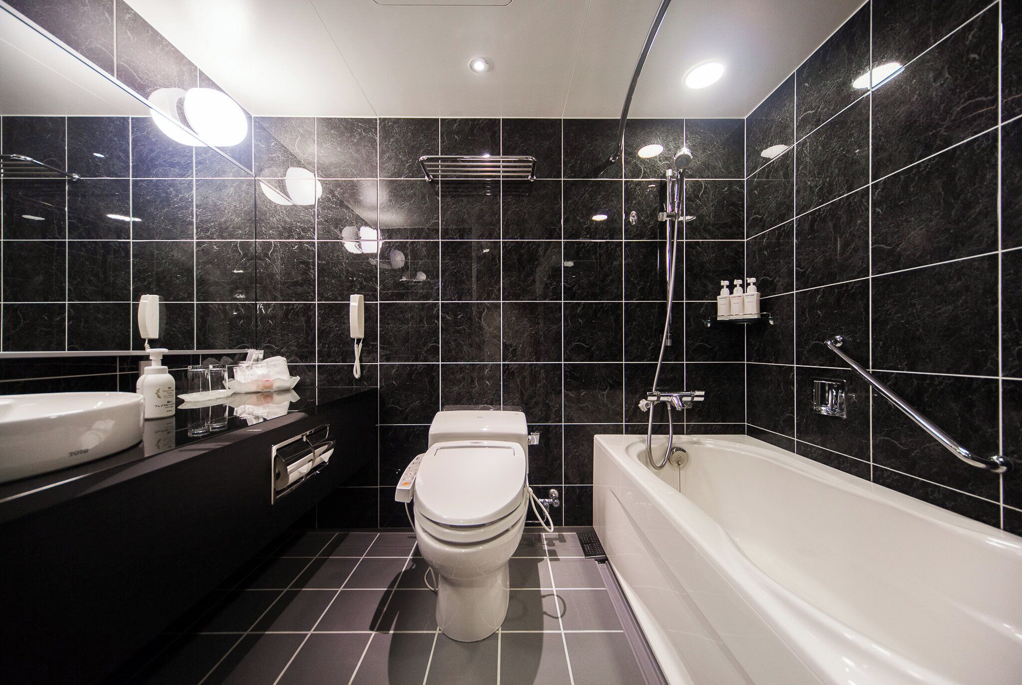 Ein modernes Badezimmer mit Toilette, Waschbecken und Badewanne.