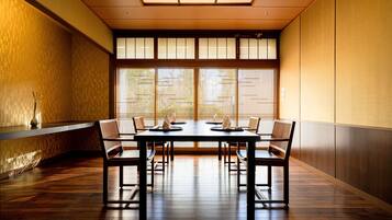 A traditional Japanese room with tatami flooring, a low table with cushions, and sliding shoji doors.