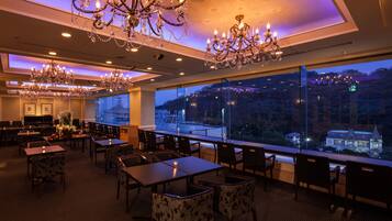 Un restaurante con varios candelabros, mesas y sillas dispuestas para comer.
