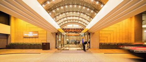 A hotel entrance with a tiled floor, a glass door, and a sign reading "ANA CROWNE PLAZA".