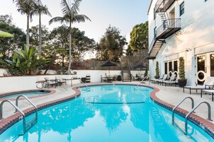 Una piscina al aire libre, sillones reclinables de piscina