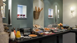 A buffet setup with various food items and beverages. - Hotel Louvre Saint Honoré (Paris)