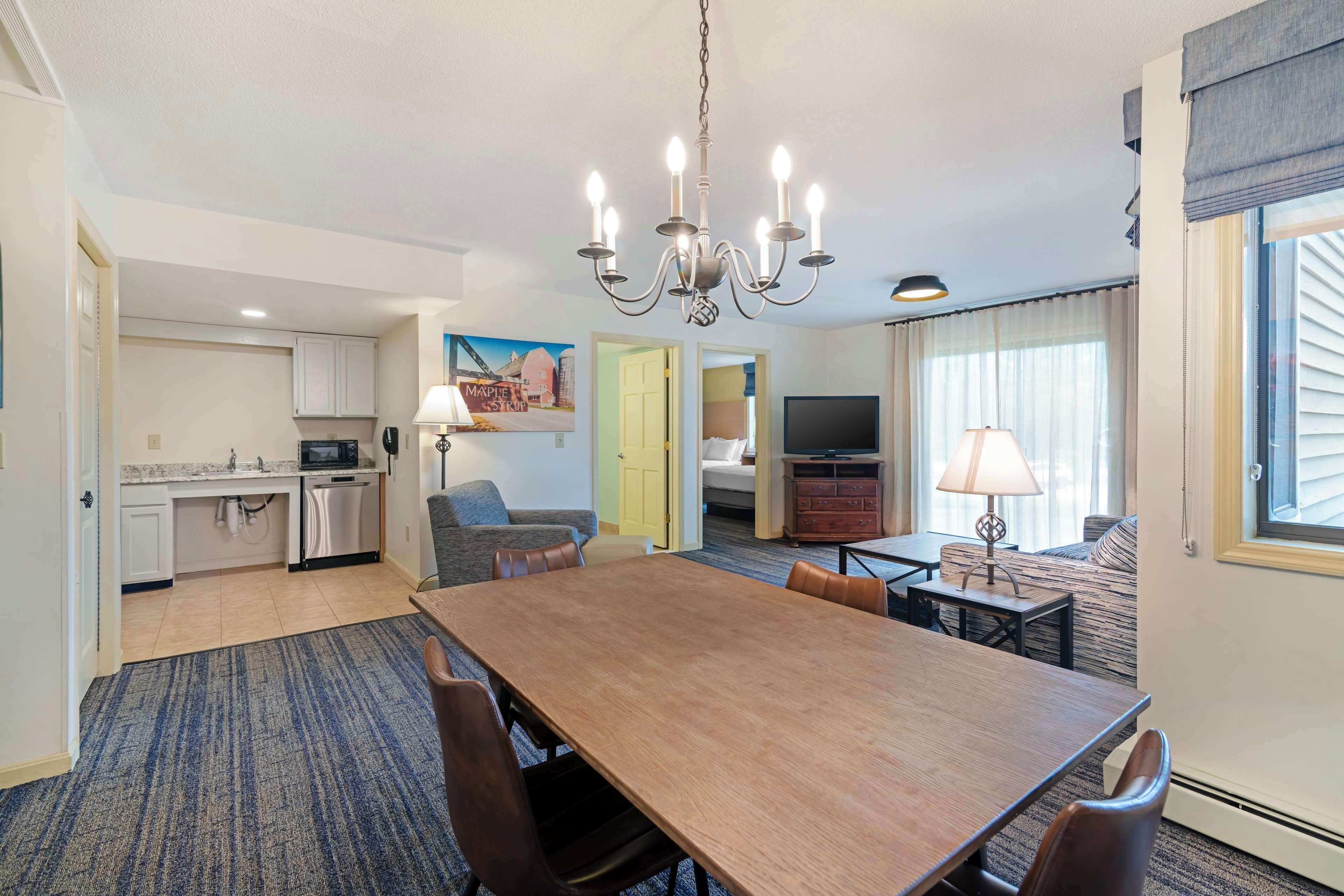 Hotelkamer met een eethoek, kitchenette en een zithoek met televisie.