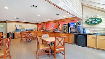 Un restaurante con mobiliario de madera, una barra con máquinas de café y un letrero de Green Mountain Coffee.