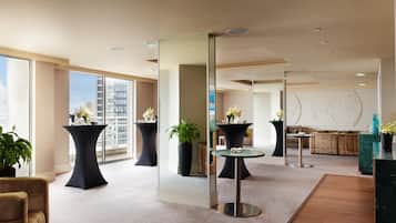 A modern hotel lobby with high ceilings, large windows, and multiple seating areas.