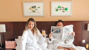 Une chambre d’hôtel avec un lit, un coin petit-déjeuner et deux tableaux encadrés au mur.