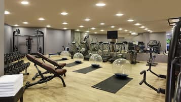 A gym with various exercise equipment, including treadmills, elliptical machines, and free weights.